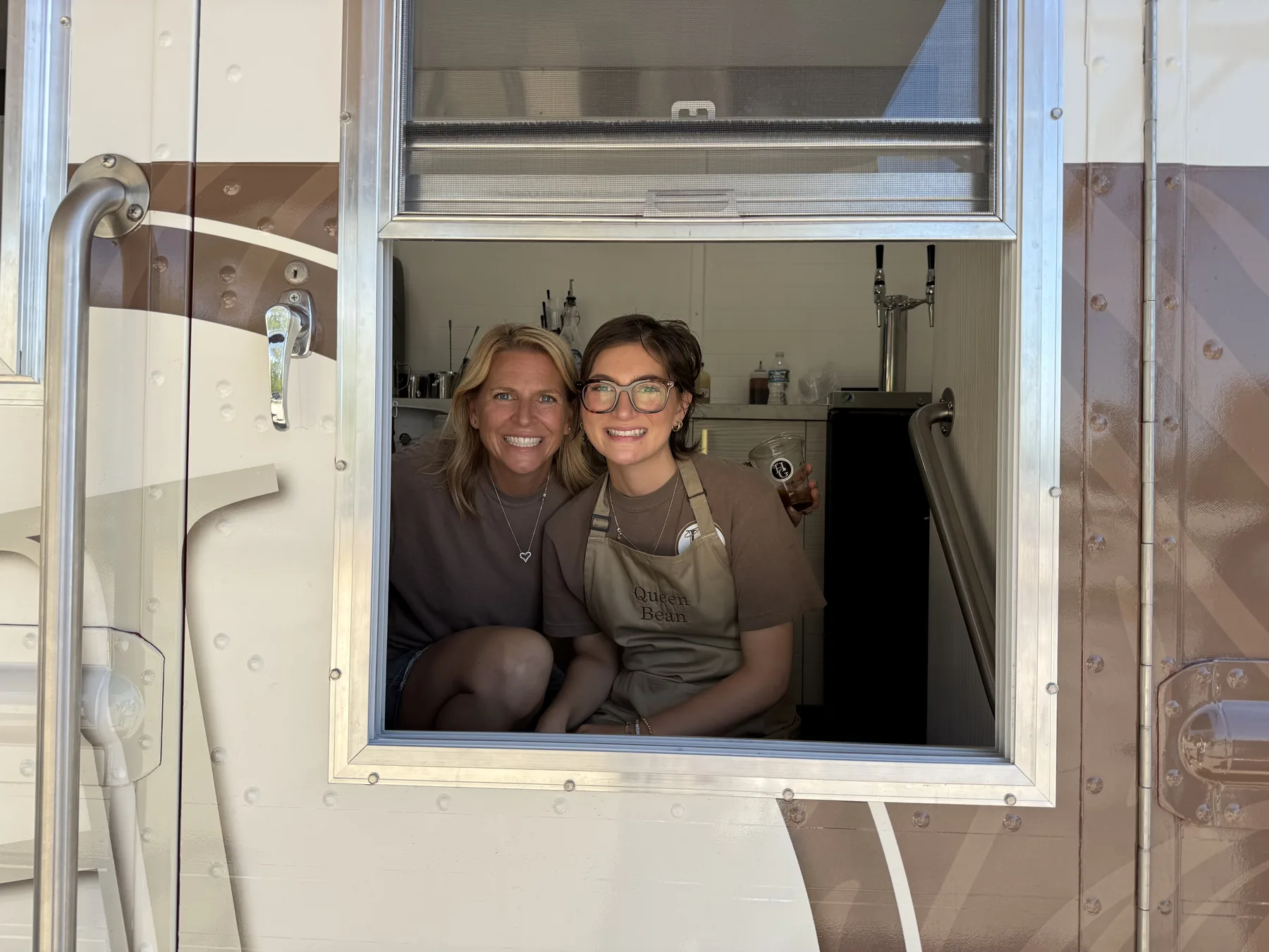 Two Holy Grounds team members smiling at a service window